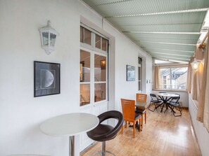 A corridor with a dining area featuring a table and chairs, a white wall with framed pictures, and a ceiling with a corrugated metal design. - Bright apartment, mountain views - 4 guests (Argelès-Gazost)