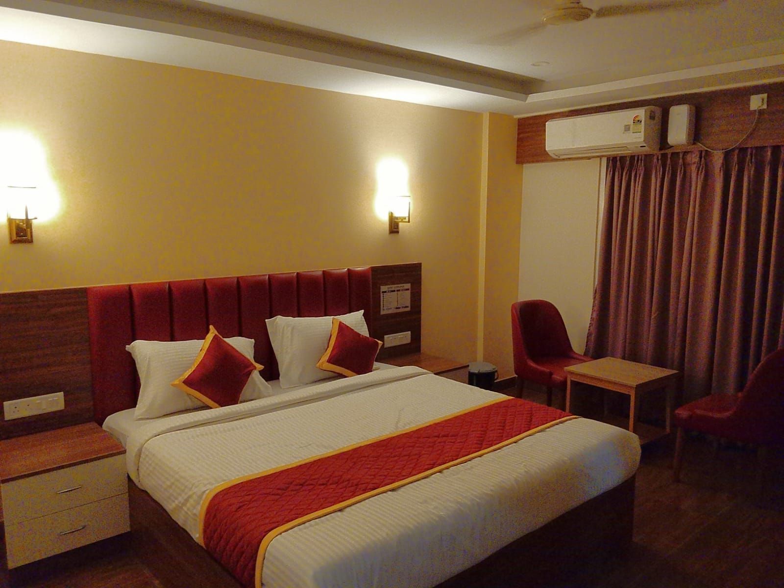 Una habitación de hotel con una cama, mesitas de noche, un escritorio y una silla.