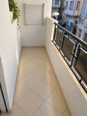 A balcony with tiled flooring, a metal railing, and a wall-mounted towel rack. - Moroccan Home • Central Tangier + Free Parking (Tanger)