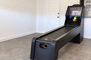 Eine schwarze Bank vor einer weißen Tür, vor der ein Spiel mit dem Titel 'ROLL AND SCORE' liegt.