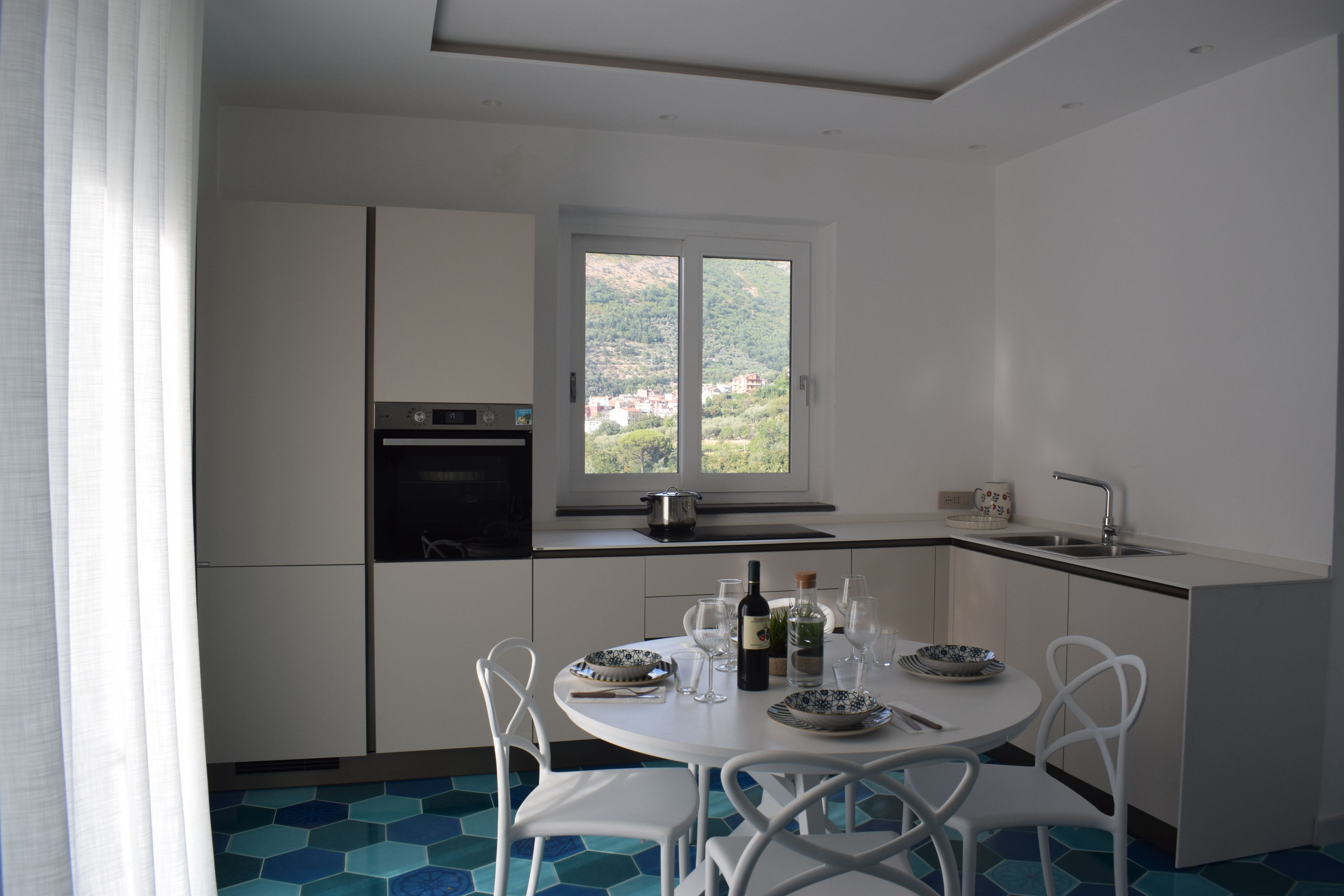 Una cucina moderna con zona pranzo, vista sulla campagna e finestra con vista sulle colline.