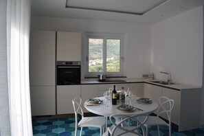 Una cucina moderna con zona pranzo, vista sulla campagna e finestra con vista sulle colline.