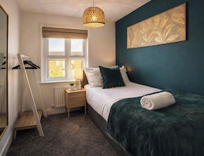 A bedroom with a bed, bedside table, lamp, window, and a wall-mounted artwork. - Prime Location Modern Home, Sleeps 5, Free Parking (Coventry)