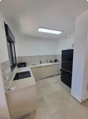 A modern kitchen with a built-in microwave, sink, and a double-door refrigerator. - Arnona Apartment - New & Modern WIth Private Mamad (Jerusalem)