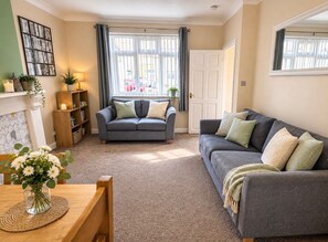 A living room with two sofas, a coffee table, and a bookshelf. - Central Property with Free Parking, Sleeps 6 (Warwickshire)