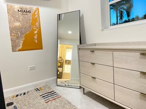 A bathroom with a light-colored vanity, a mirror, a map of Miami on the wall, and a patterned rug. - Modern 4-bedroom Oasis in North Miami w/ HOT TUB (Miami)