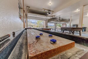A pool table with four blue corner pockets, a billiards table, and a view of mountains through large windows. - Mountain Views - Hot Tub Two Game Rooms (Monument)
