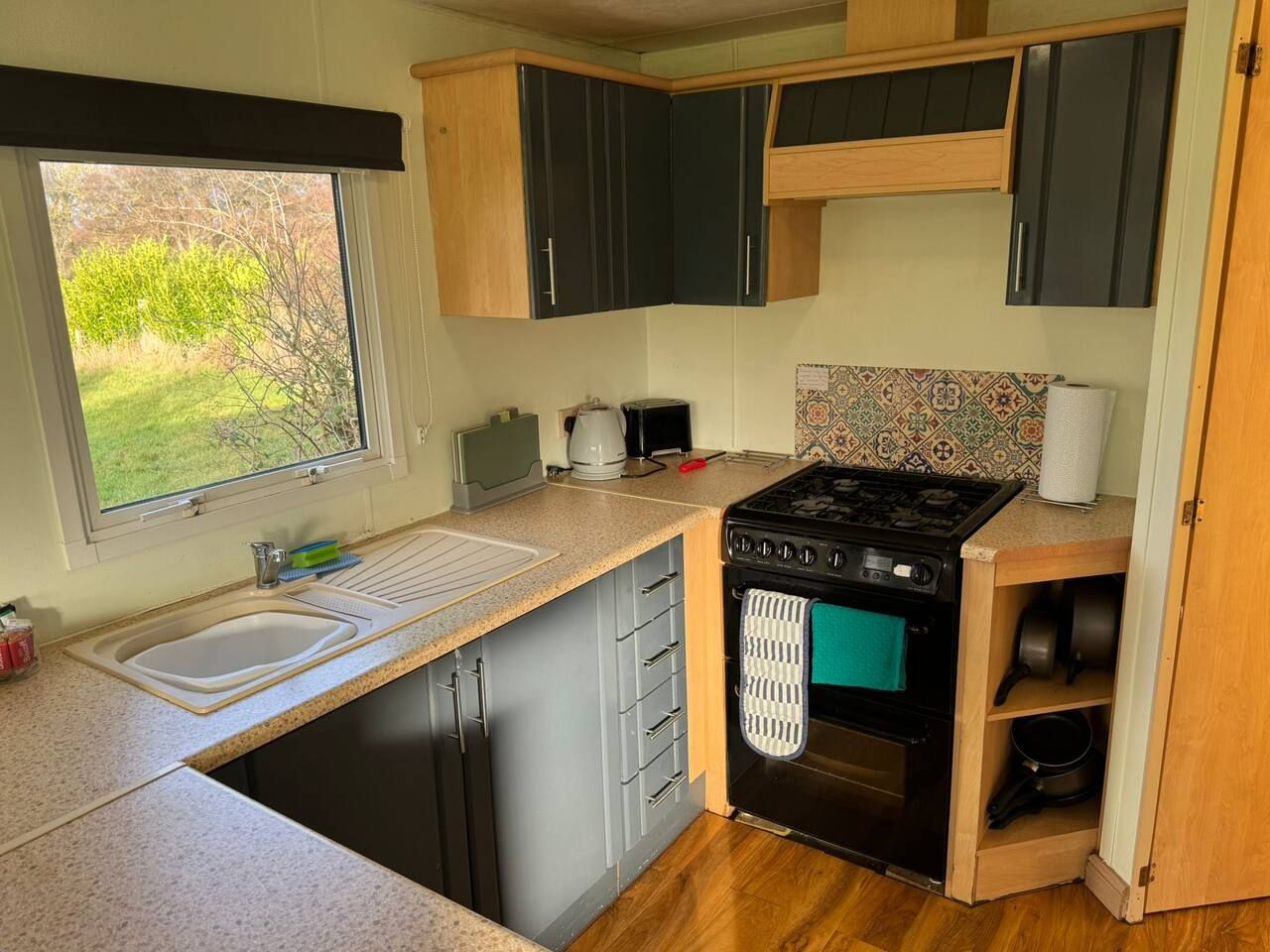 A compact kitchen with a sink, stove, and cabinets.