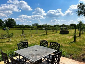Sunny patio dining with orchard views and wide-open countryside
