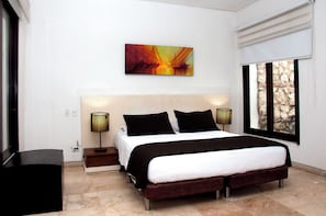 Un dormitorio moderno con una cama grande, lámparas de noche, un cuadro en la pared y una ventana con vistas.