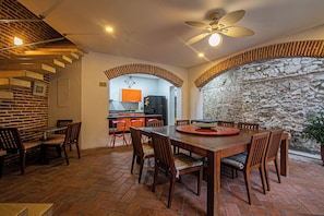 Un comedor con pared de ladrillo, mesa de madera y sillas.