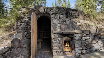 A stone structure with a wooden door and a fireplace.