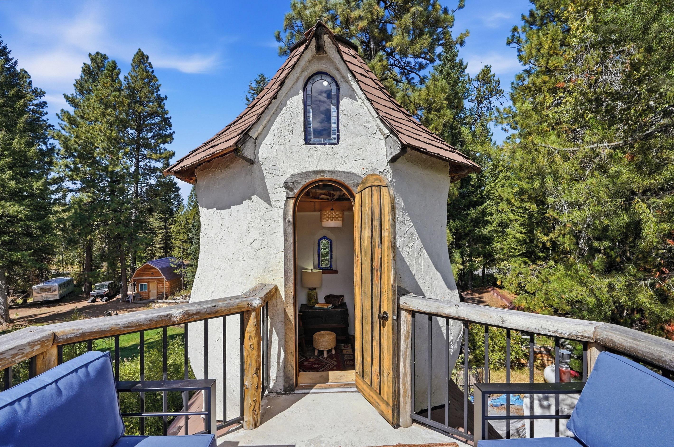 Une construction rustique en bois, dotée d’un toit à deux versants et d’une petite entrée en arc de cercle.