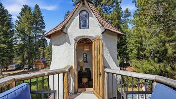 Une construction rustique en bois, dotée d’un toit à deux versants et d’une petite entrée en arc de cercle.