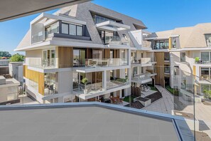 Een meerlaags woongebouw met balkons, grote ramen en een modern architectonisch ontwerp.