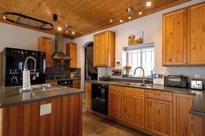 A modern kitchen with wooden cabinets, stainless steel appliances, and a granite countertop.