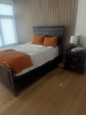 A bedroom with a bed, a nightstand, a lamp, and a window. -  Room with ultra-modern amenities . Newly built house -facing Tampa river. (Tampa)