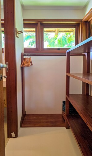 A walk-in closet with wooden shelving, a coat rack, and a window with a view of greenery. - 4-bedroom house in fabulous Trancoso with AC and fitness room (Trancoso)