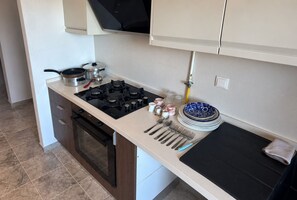 Eine Küche mit einem Herd, Backofen und verschiedenen Kochutensilien.