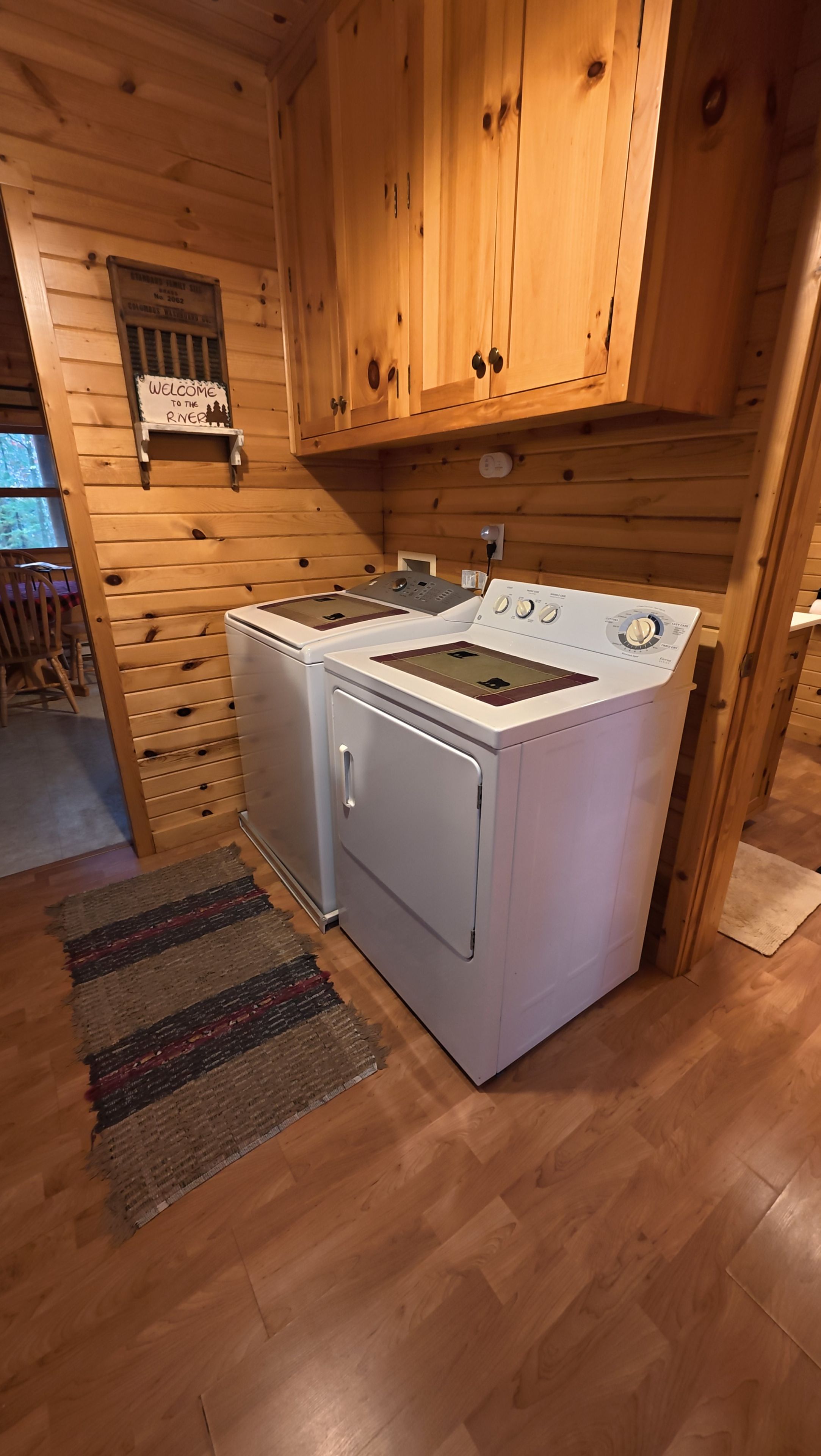 Een praktische keuken met houten kastjes, een wasmachine en een fornuis.
