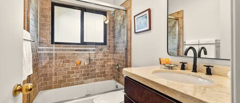 A bathroom with a bathtub, toilet, and sink.