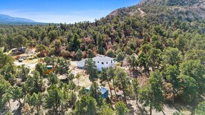A white building surrounded by dense forest and mountains. - Peaceful Country Retreat in Regina (Regina)