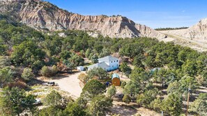 A residential area with a house surrounded by trees and a mountain in the background. - Peaceful Country Retreat in Regina (Regina)
