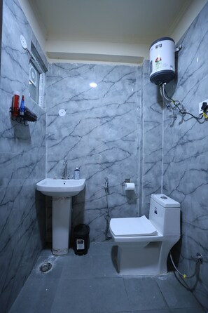 A compact bathroom with a sink, toilet, and shower. - Forest view 1BHK Premium studio appartment (New Delhi)