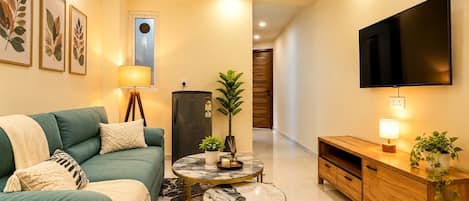 A modern living room with a sofa, a coffee table, a TV, and a cabinet.