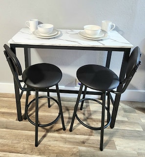 A white table with two black chairs and white cups and saucers. - Private King Studio near Beach, FLL & Hard Rock (Hollywood)