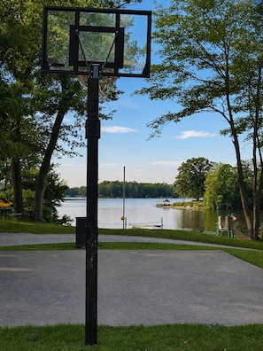 Canasta de baloncesto en un parque con vista al lago.