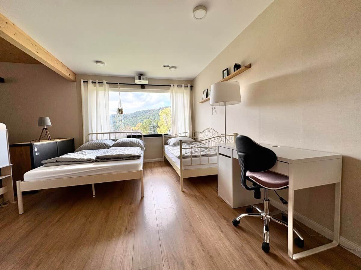 Une chambre avec deux lits, un bureau et une chaise.