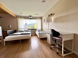 Une chambre avec deux lits, un bureau et une chaise.