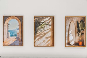 Trois œuvres d’art encadrées sont accrochées au mur.