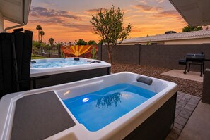 Ein Whirlpool mit freiem Blick auf einen Sonnenuntergang und einer Kakteen-Mural im Hintergrund.