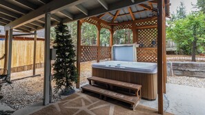 A hot tub under a wooden pergola with a wooden fence in the background. - Romantic Cabin with Hot Tub & Charming Dutch‑Style Decor. Perfect for couples! (Big Bear)