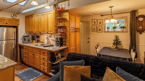 Eine Küche mit Holzausstattung, einem Edelstahlkühlschrank und einem Essbereich mit Tisch und Stühlen.