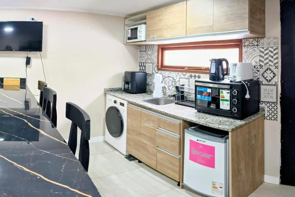 A compact kitchen with a microwave, coffee maker, and a small refrigerator.