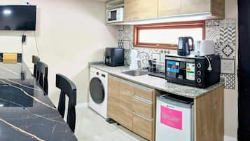 A compact kitchen with a microwave, coffee maker, and a small refrigerator.