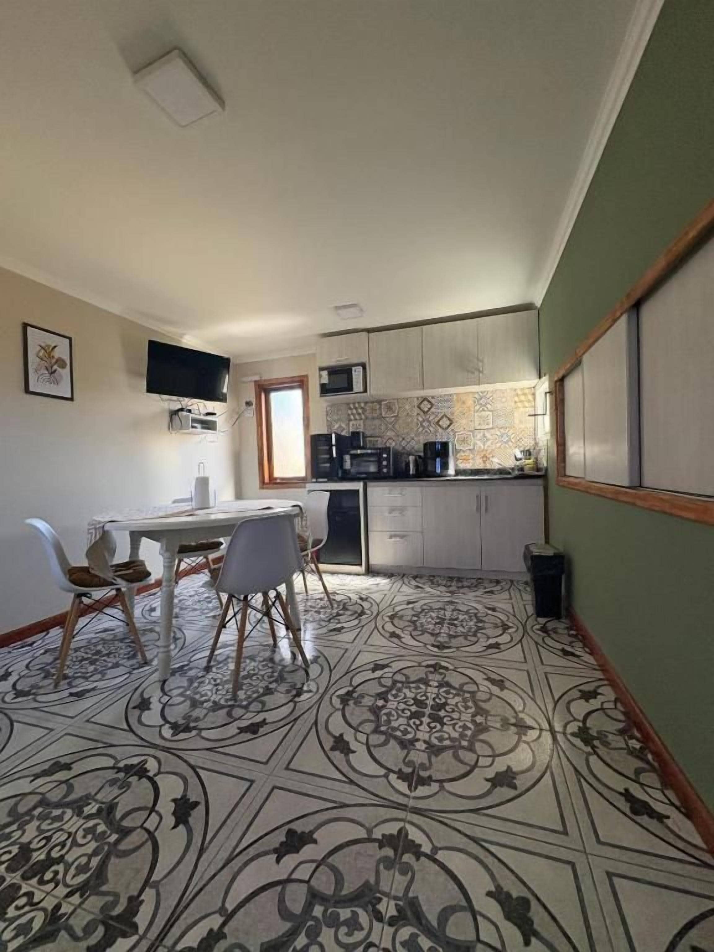 A compact kitchen with a dining area, a microwave, and a coffee machine.