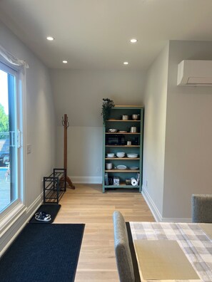 A modern kitchen with a built-in microwave, a wooden rack, and a teal-colored shelving unit with dishes. - Charming York Sanctuary with Private Rooftop Oasis (Toronto)