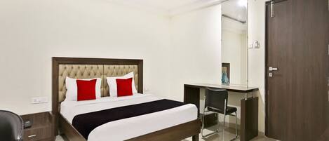 Una habitación de hotel con cama, escritorio, silla y armario.