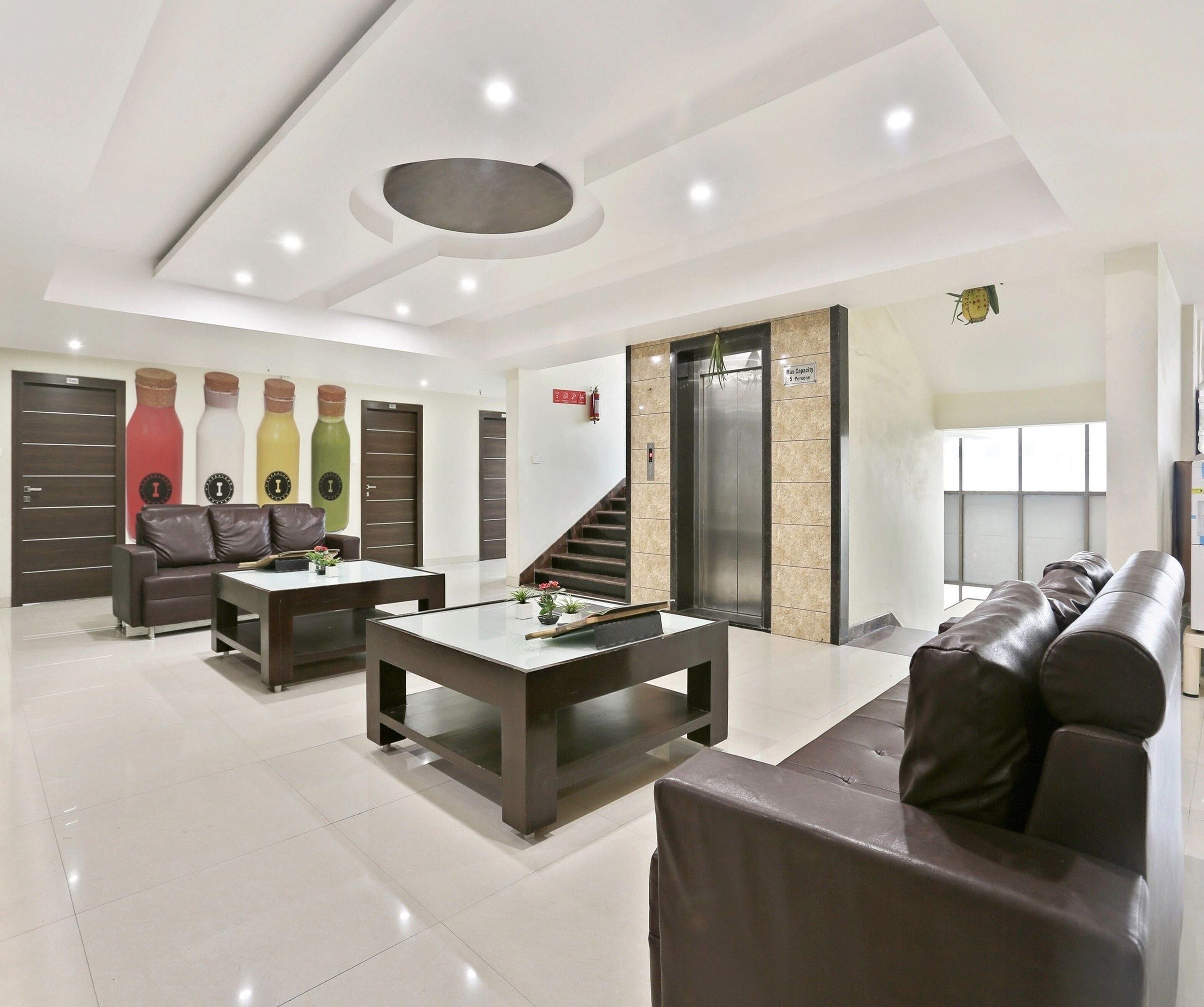 A modern living room with a sofa, coffee table, and a staircase leading to an elevator.