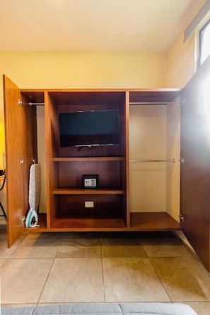 Un armario amplio con puertas de madera, una barra para colgar ropa y un módulo de almacenamiento.