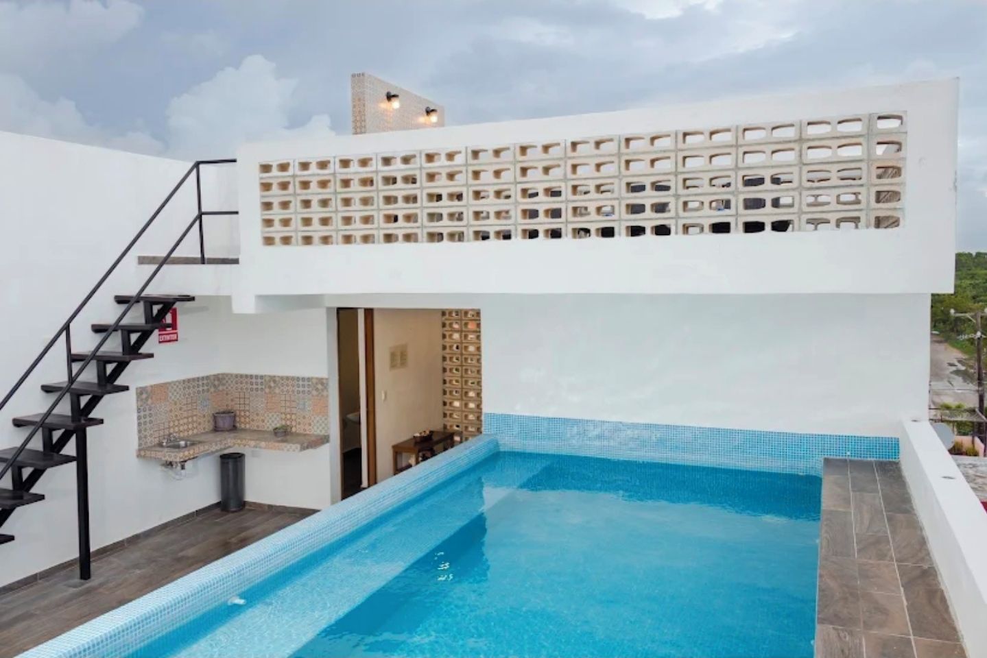 Ein Pool auf dem Dach mit modernem Design, einer Treppe und Blick auf die umliegende Landschaft.