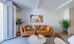 A modern living room with a sofa, a coffee table, and two potted plants. - IDEALLY LOCATED JUST 100 METRES FROM THE ICONIC PALAIS DES FESTIVALS (Cannes)