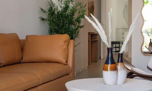 A tan leather sofa, a white round table, and two vases with white feathers. - IDEALLY LOCATED JUST 100 METRES FROM THE ICONIC PALAIS DES FESTIVALS (Cannes)