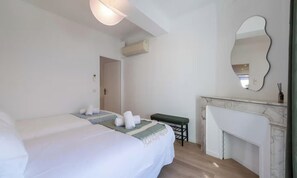A hotel room with two beds, a bench, a fireplace, and a mirror. - IDEALLY LOCATED JUST 100 METRES FROM THE ICONIC PALAIS DES FESTIVALS (Cannes)