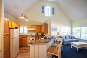 A spacious kitchen with wooden cabinets, a central island, and a dining area with a table and chairs. - Spacious 3 Bedroom 4 miles to Disney Great Resort (Kissimmee)