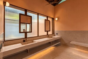 A modern bathroom with a long vanity, two sinks, and a large mirror. - Raht Aashyana Lakhanpal Goa (Candolim)
